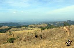 The pacific coast looms off in the distance and a rider looks on into the Nicoya gulf on April 17, 2013.