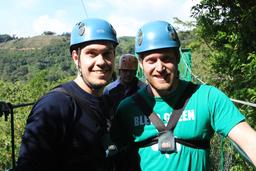 Friends don helmets and work gloves while walking on a platform between cables on April 17, 2013.