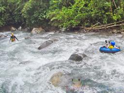 guide waiting to receive a kid in the rapids blue river tubing rincon de la vieja