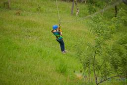 young girl riding a cable on blue river zipline rincon de la vieja