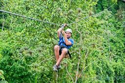 a man zip lining sitting down los canones canopy tour la fortuna