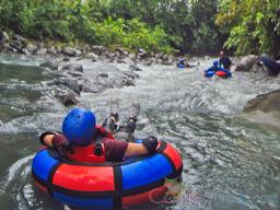 kid on an inner tube floating toward the currents blue river rincon de la vieja