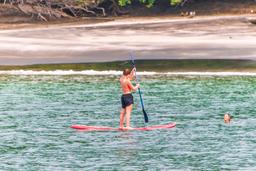 lady doing stand up paddle in playa huevos marlin del ray catamaran