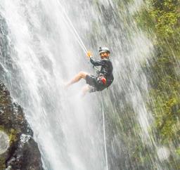 man smiling while rappelling down horseback rapelling tour rancho tropical matapalo