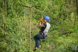 woman riding a zip line cable blue river zipline rincon de la vieja