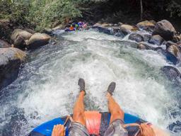 white water and people floating in front rio negro tubing rincon de la vieja