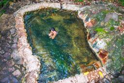 lady soaking on a warm cement pool hot springs pools rincon de la vieja