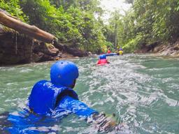wading in the blue river to get inner tube rincon de la vieja