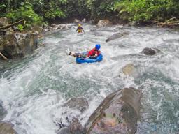 lady tubing on the rocky rapids of blue river rincon de la vieja