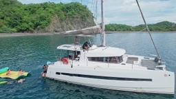 lateral view with people snorkeling and playing in the water 41 foot luxury charter catamaran guanacaste