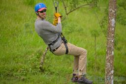 man riding a cable on blue river zipline rincon de la vieja