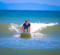 lady starting to stand on board pollo surf school matapalo